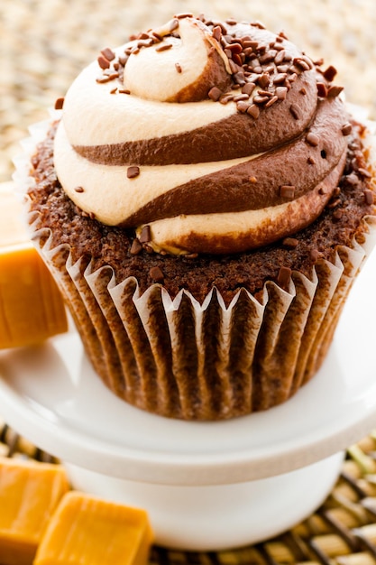 Gourmet-Schokoladen-Karamell-Swirl-Cupcake mit Schokoladenstreuseln.