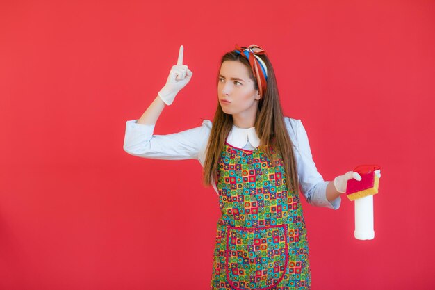 Governanta de uniforme com governanta de esponja limpa ou esposa feliz limpando com garrafa de sabão