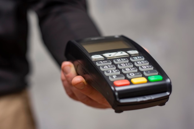 Foto gprs-zahlungs-pos-terminal auf einem tisch mit einem laptop ausrüstung für die zahlung per bankkarte