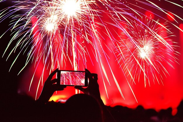Grabación de fuegos artificiales con teléfono inteligente durante la fiesta de Año Nuevo