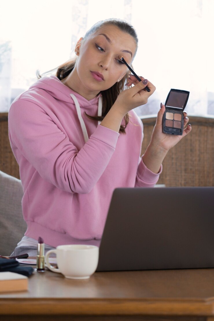 Foto grabación de mujer hermosa joven maquillaje tutorial para compartir en las redes sociales, transmitiendo video vlog en línea con cosméticos de maquillaje en casa