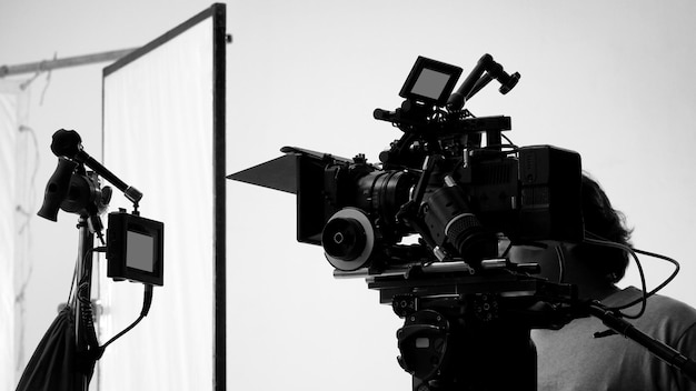 Grabación de películas o producción de filmación de videos por parte de un equipo de trabajo y equipo profesional, como una cámara digital de súper ultra alta definición con trípode e iluminación en estilos de estudio y en blanco y negro