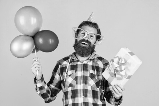 gracias feliz cumpleaños a usted fiesta masculina hombre barbudo con globos de fiesta y caja de regalos hombre brutal sin afeitar con barba celebrar el éxito del negocio expresar la felicidad pura