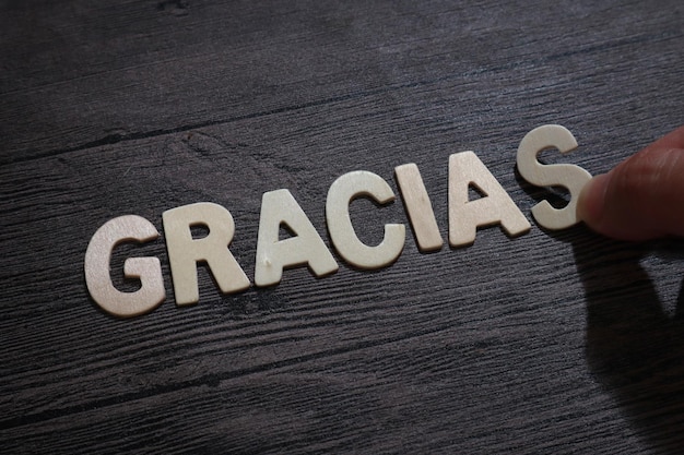 Gracias gracias en español texto palabras tipografía escrita con letra de madera sobre fondo negro
