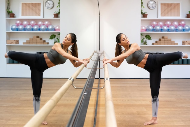 Graciosa bailarina étnica joven haciendo ejercicio en el estudio