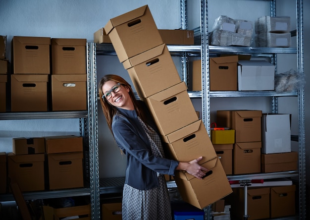 Foto graciosa empresaria sosteniendo cajas de almacenamiento