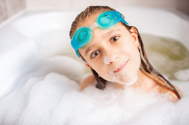 Graciosa niña caucásica positiva con gafas de natación