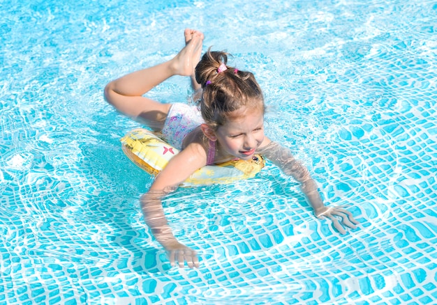 Graciosa niña nadando en la piscina