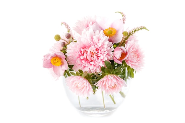 Gracioso buquê de outono de anêmonas de flores de áster rosa em vaso de vidro redondo isolado em fundo branco