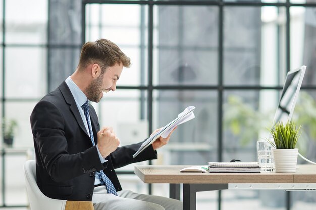 Gracioso empleado masculino diviértete realizando ganador en la oficina moderna