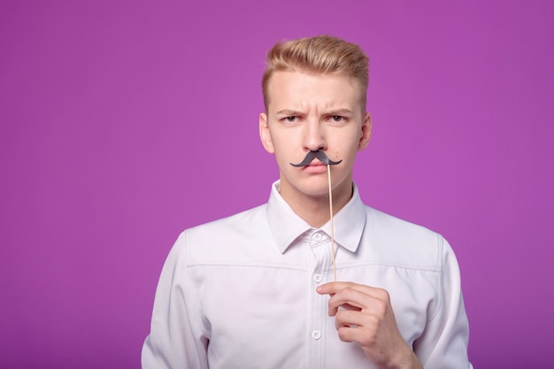 Gracioso joven con bigote de papel en