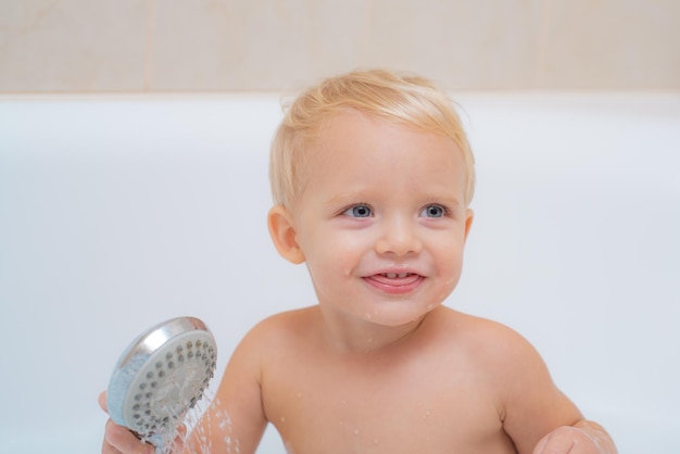 Gracioso lindo bebé está nadando en espuma en el baño Cute little baby boy tomando baño jugando con espuma a