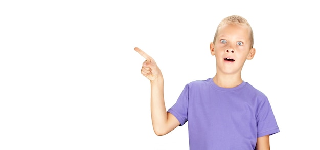 Gracioso niño sorprendido señalando con la mano y el dedo aislado sobre fondo blanco con espacio de copia