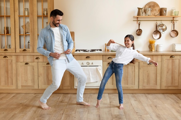 Gracioso padre e hija del Medio Oriente bailando en la cocina