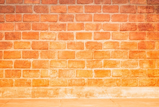 Gradiente de pared de ladrillo naranja y espacio con líneas de concreto crema para el fondo de montaje del producto