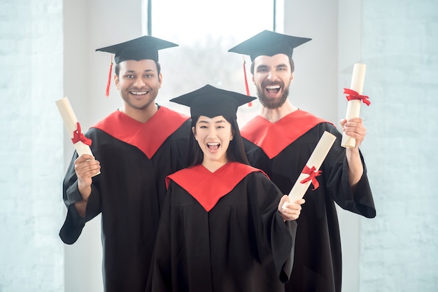 Graduação. Graduados em mortarboards parecendo felizes e alegres