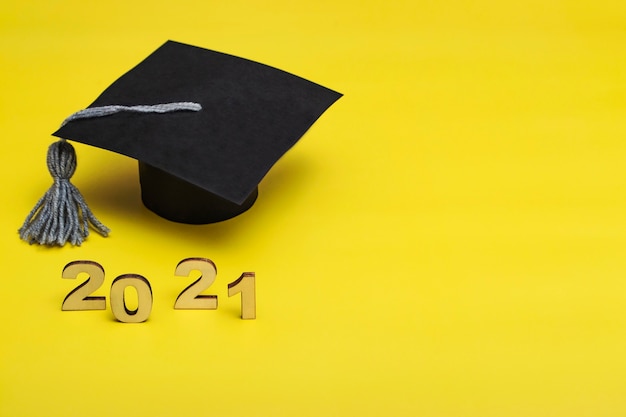 Foto graduación 2021. gorra de posgrado sobre fondo amarillo. plantilla de posgrado 2021