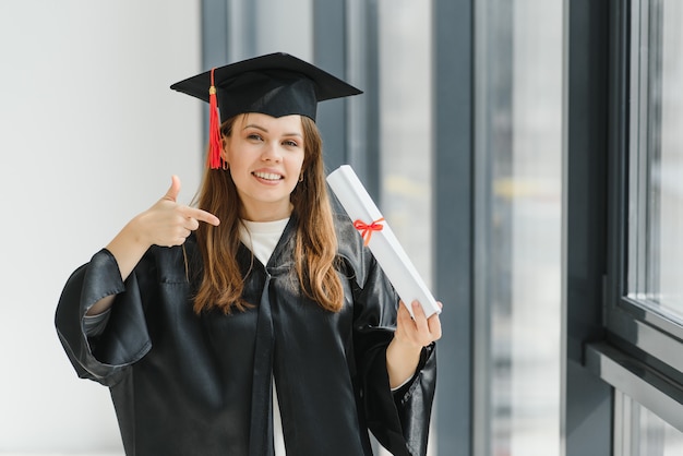 Graduación: estudiante de pie con diploma