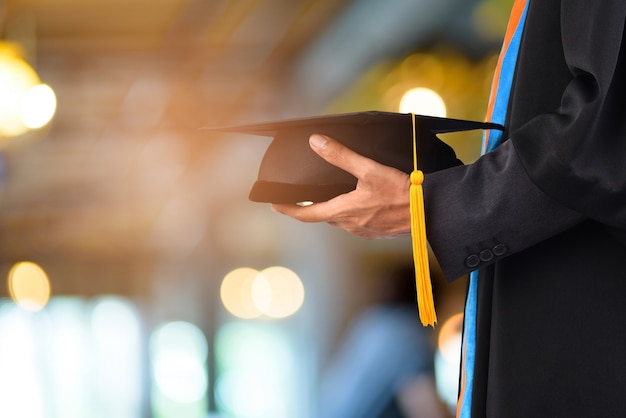 La graduación toma una borla amarilla negra delante del fondo borroso del bokeh