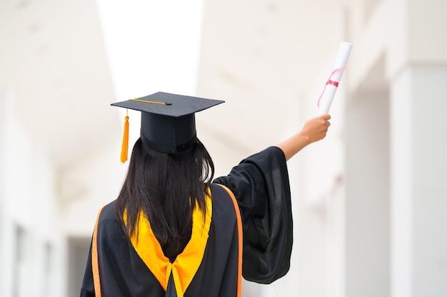 Graduadas femininas usam vestidos pretos e borlas amarelas esperando para participar da cerimônia de formatura na universidade