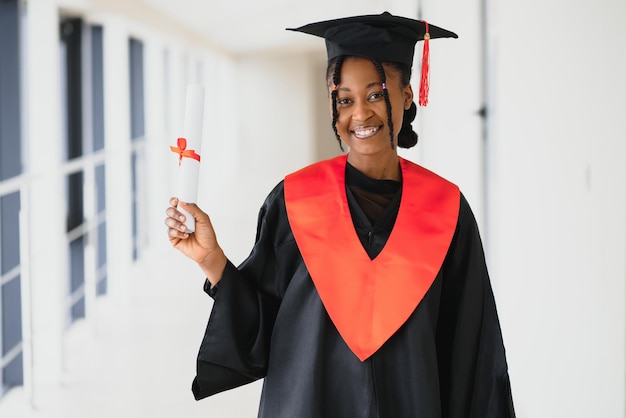 Graduado afroamericano joven hermoso que sostiene el diploma