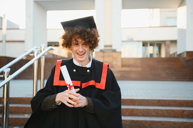 Foto graduado bonito em brilho de formatura com diploma