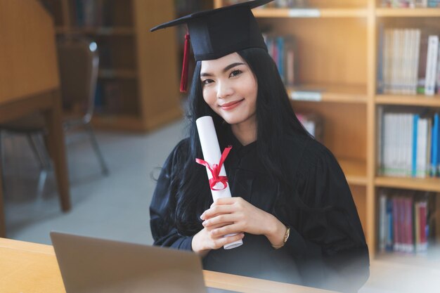 Graduado em vestido de formatura e papelão celebra em uma cerimônia de formatura virtual