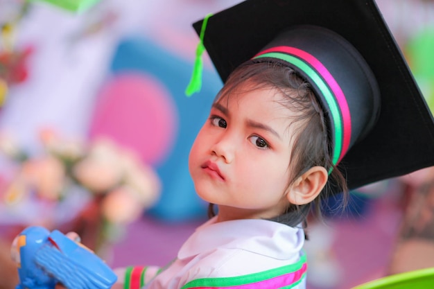 Graduado de niño de escuela asiática en gorro de graduación