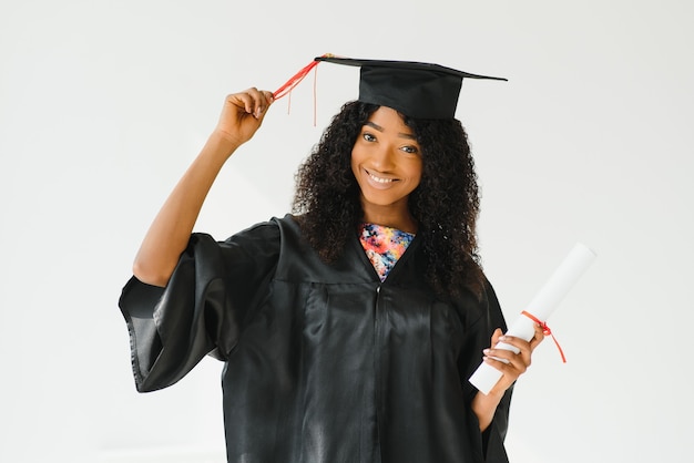 Graduado universitario afroamericano femenino atractivo sobre fondo blanco