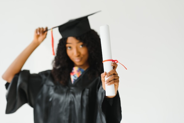 Foto graduado universitario afroamericano femenino atractivo sobre fondo blanco