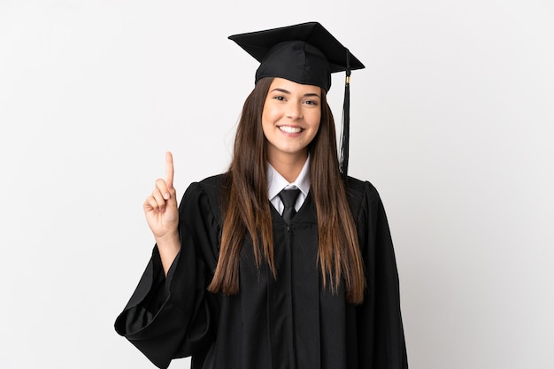 Graduado universitario brasileño adolescente sobre fondo blanco aislado apuntando hacia una gran idea