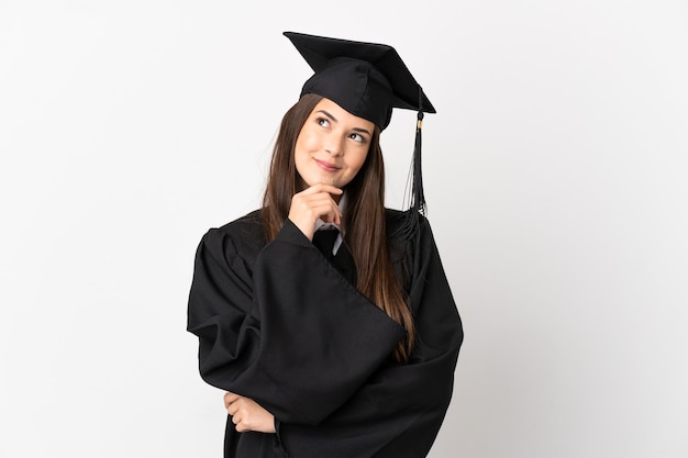 Foto graduado universitario brasileño adolescente sobre fondo blanco aislado y mirando hacia arriba