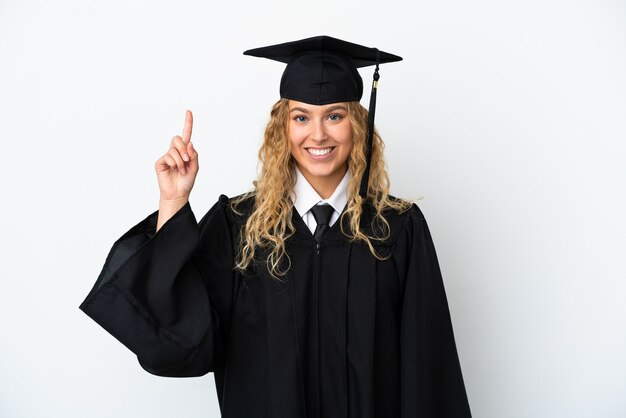 Graduado universitario joven aislado sobre fondo blanco apuntando hacia una gran idea