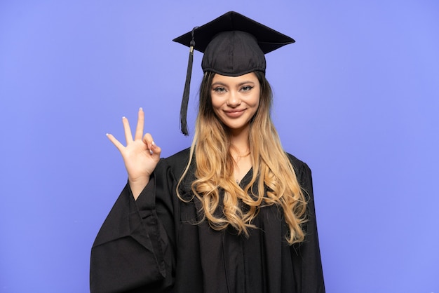 Graduado universitario joven chica rusa aislada sobre fondo blanco mostrando signo ok con los dedos