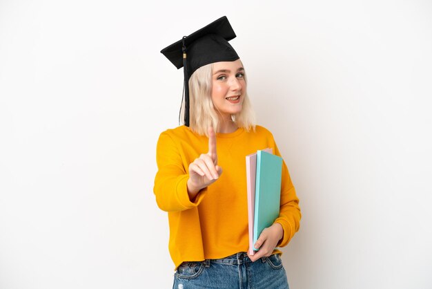 Graduado universitario joven mujer caucásica aislado sobre fondo blanco mostrando y levantando un dedo