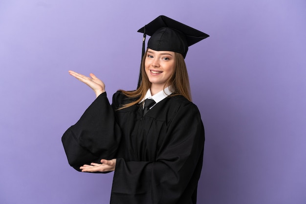 Graduado universitario joven sobre fondo púrpura aislado extendiendo las manos hacia el lado para invitar a venir