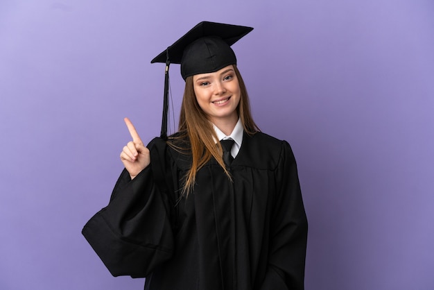 Graduado universitario joven sobre fondo púrpura aislado mostrando y levantando un dedo en señal de lo mejor