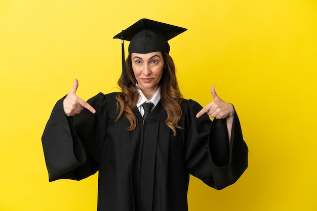 Graduado universitario de mediana edad aislado sobre fondo amarillo orgulloso y satisfecho de sí mismo