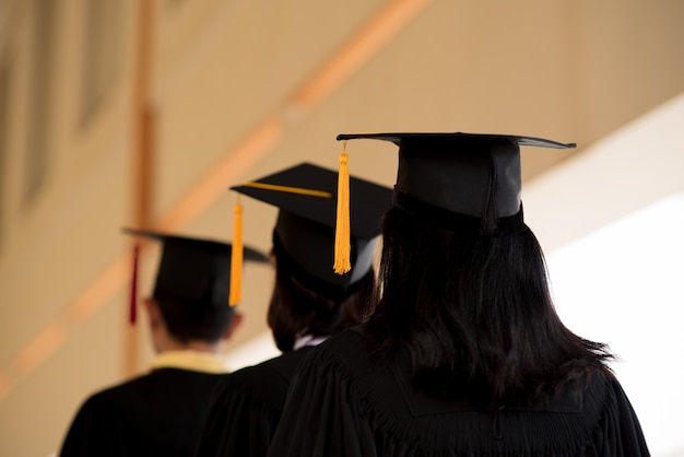 Los graduados negros usan trajes negros el día de la graduación en la universidad.