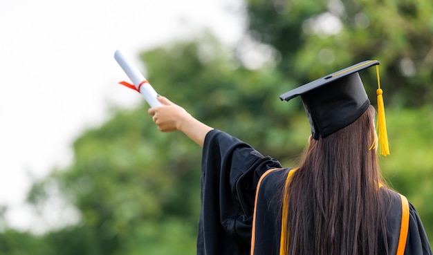 Graduierungskappe mit goldener Quaste, die ein Diplom hält Erfolgsabsolventen der UniversitätConcept Education Gratulation Absolventen der Universität