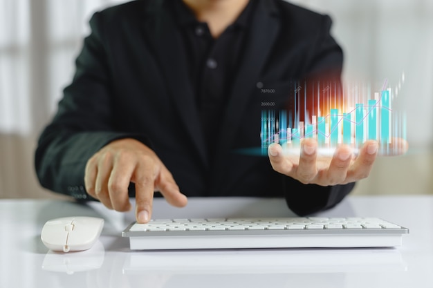 Foto gráfico de barras de comercio en el empresario de mano con el uso de teclado de computadora, gráfico de análisis de marketing de la bolsa de valores. información estadística diagrama beneficio. concepto de inversión y marketing.