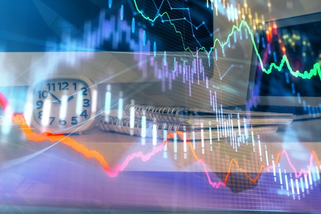 Gráfico bursátil sobre fondo con escritorio y computadora personal Concepto de exposición múltiple de análisis financiero