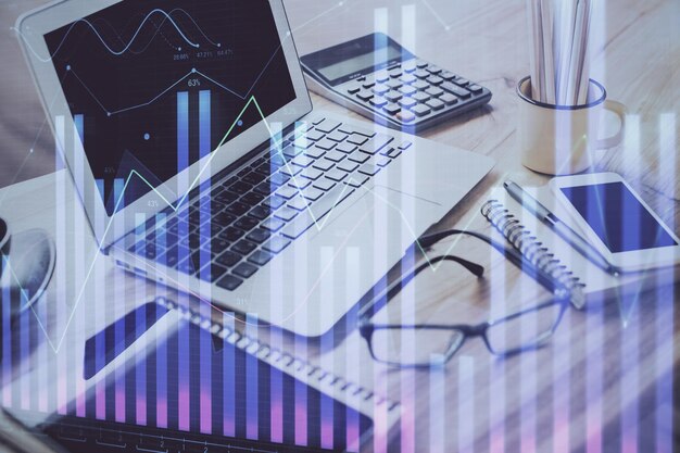 Gráfico bursátil sobre fondo con escritorio y computadora personal Concepto de exposición múltiple de análisis financiero