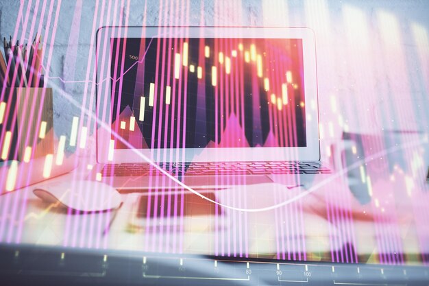 Gráfico bursátil sobre fondo con escritorio y computadora personal Concepto de exposición múltiple de análisis financiero
