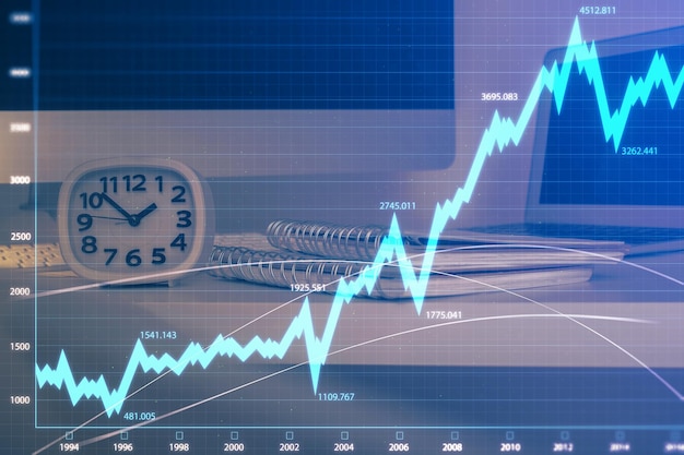 Gráfico bursátil sobre fondo con escritorio y computadora personal Concepto de exposición múltiple de análisis financiero