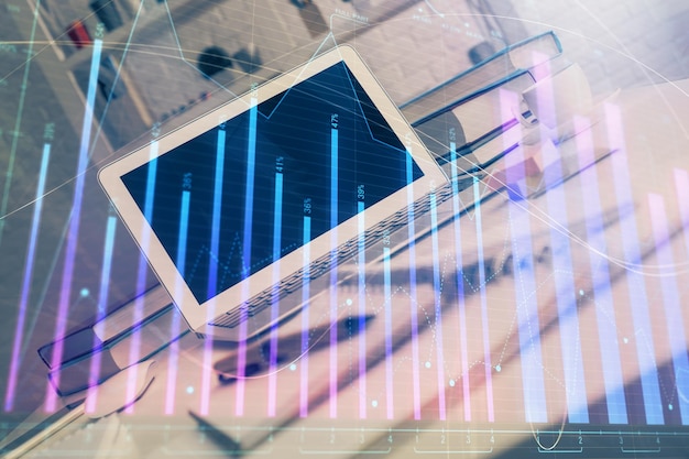 Gráfico bursátil sobre fondo con escritorio y computadora personal Concepto de exposición múltiple de análisis financiero