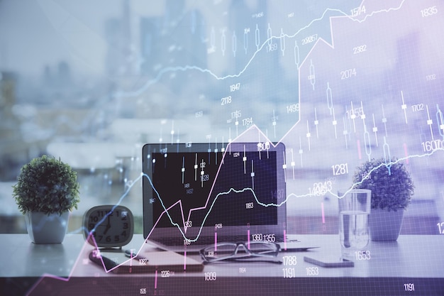Gráfico bursátil sobre fondo con escritorio y computadora personal Concepto de exposición múltiple de análisis financiero