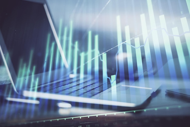 Gráfico bursátil sobre fondo con escritorio y computadora personal Doble exposición Concepto de análisis financiero