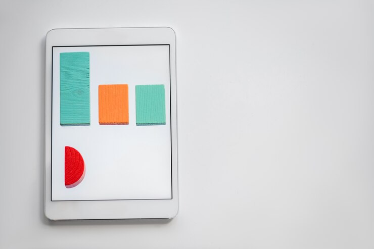 Foto gráfico de colores compuesto por ladrillos de madera planos que yacen en fila en la pantalla de la tableta digital con copyspace a la derecha