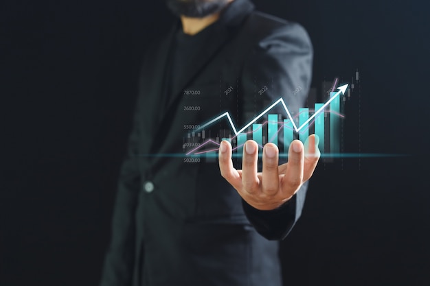 El gráfico comercial aparece de la mano del empresario, el gráfico de análisis de marketing bursátil. información estadística diagrama beneficio. concepto de inversión y marketing.